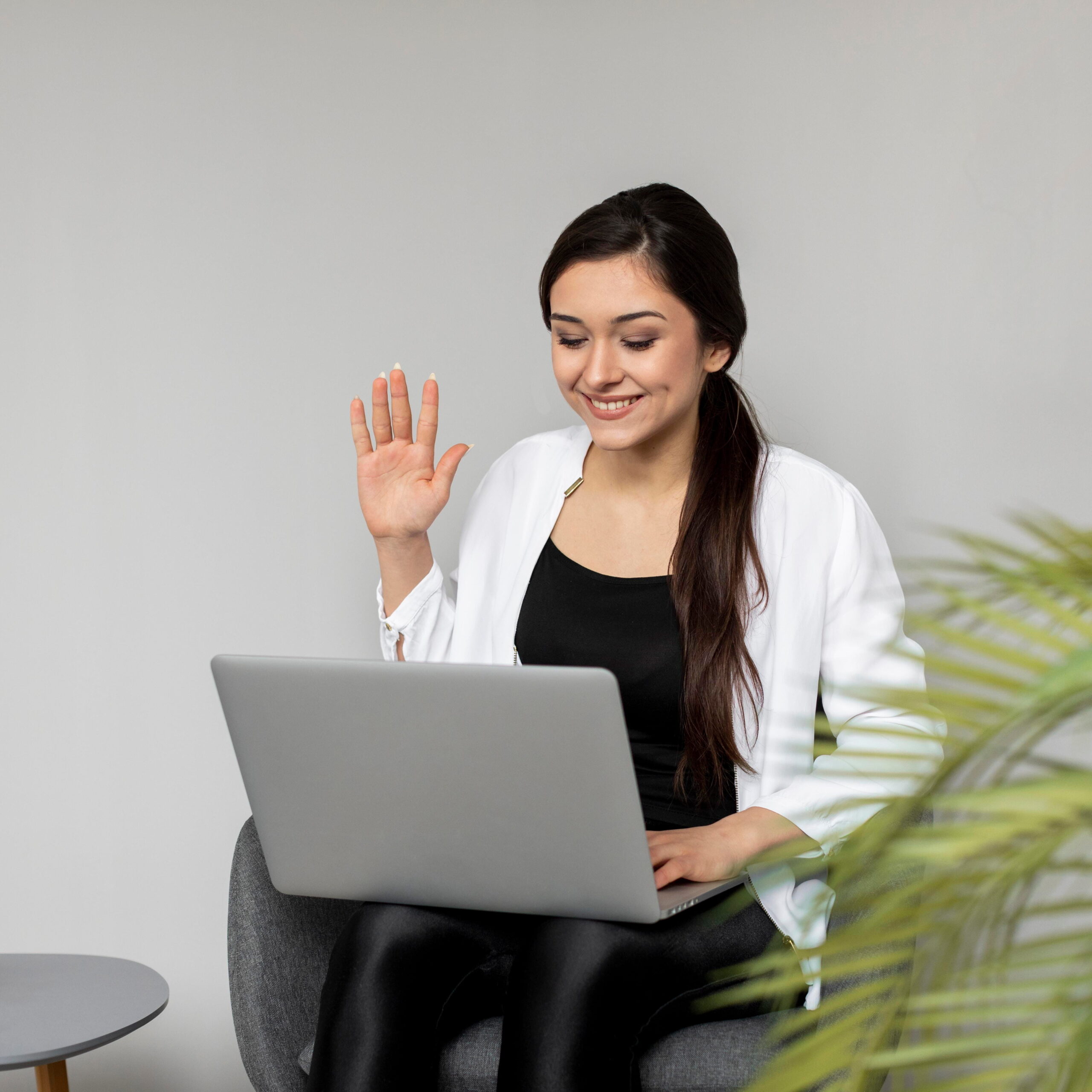 medium-shot-woman-waving-laptop(1)